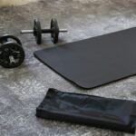 a pair of dumbbells and a black mat on the floor