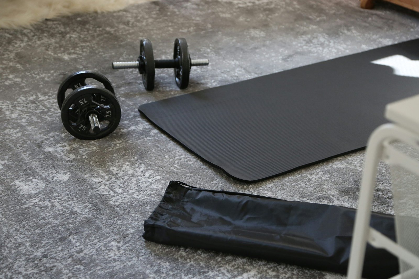 a pair of dumbbells and a black mat on the floor